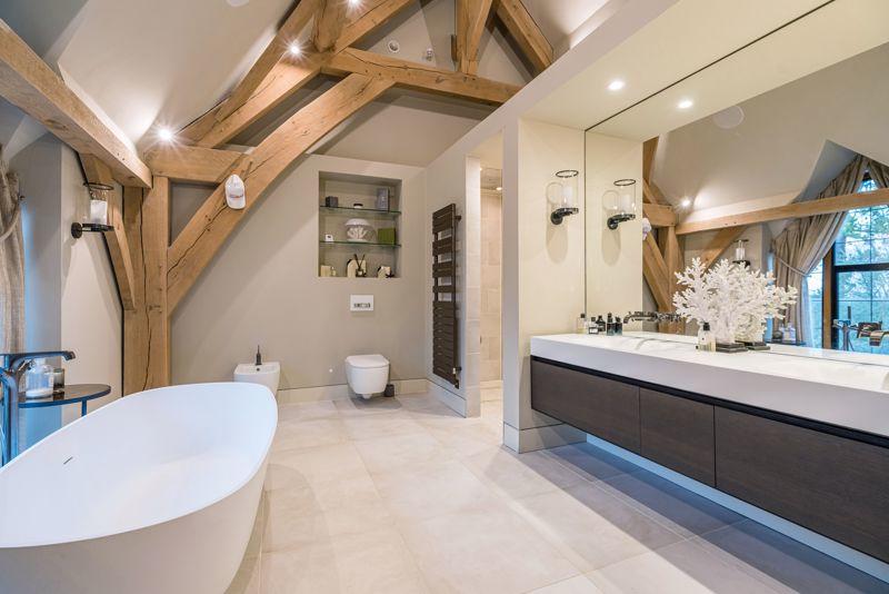 Luxury bathroom with oak beams, freestanding bath and double vanity – Kings Interiors, Oxfordshire interior design.