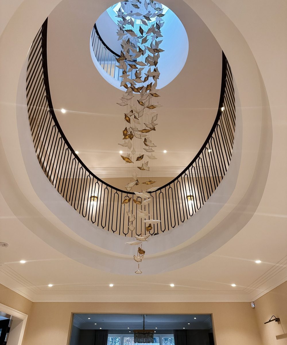 Grand double-height staircase with sculptural chandelier in Kingswood, Surrey new build home